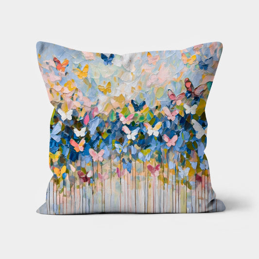 Bohemian throw pillow with an abstract butterfly wings-inspired impasto design in blue, yellow, green, and pink, featuring a textured drip effect.